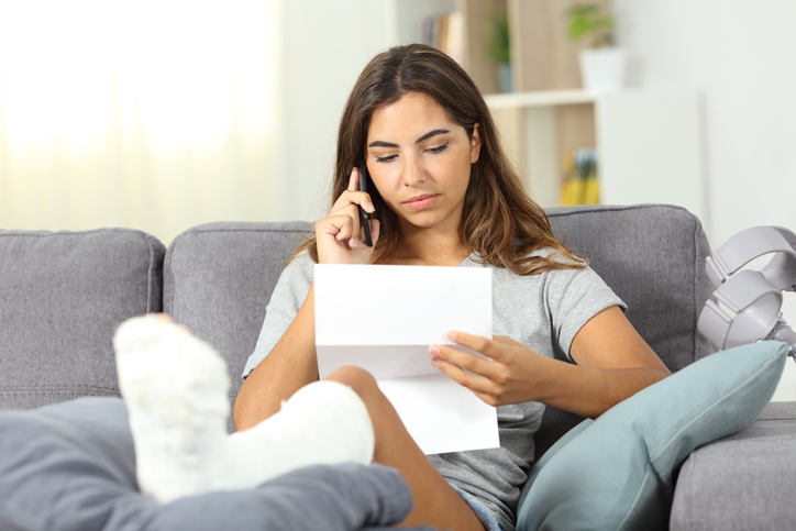 News & Information 10 a woman with a cast on her leg talking on the phone while reading a letter